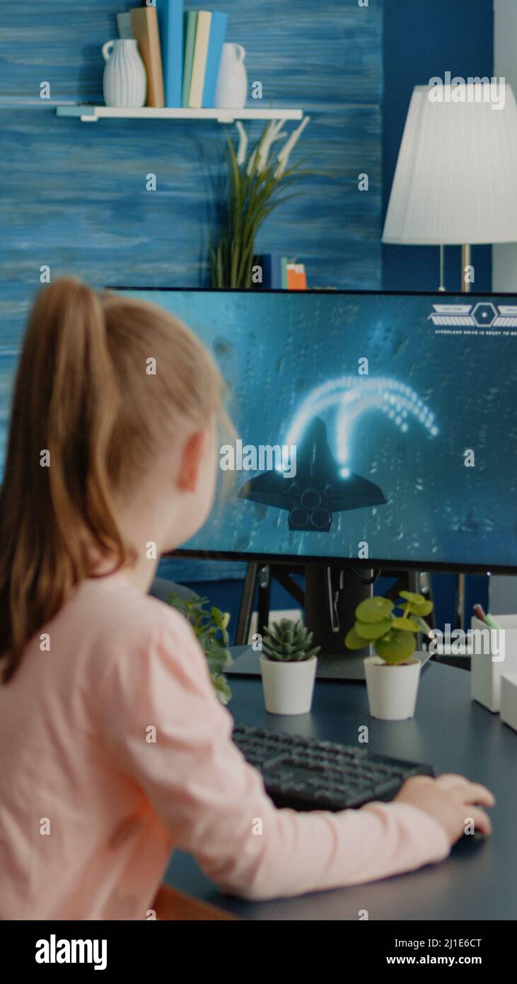 Young girl playing video games on computer after online school and  homework. Gamer using shooting action play for entertainment and fun with  keyboard and monitor. Child enjoying game Stock Photo - Alamy