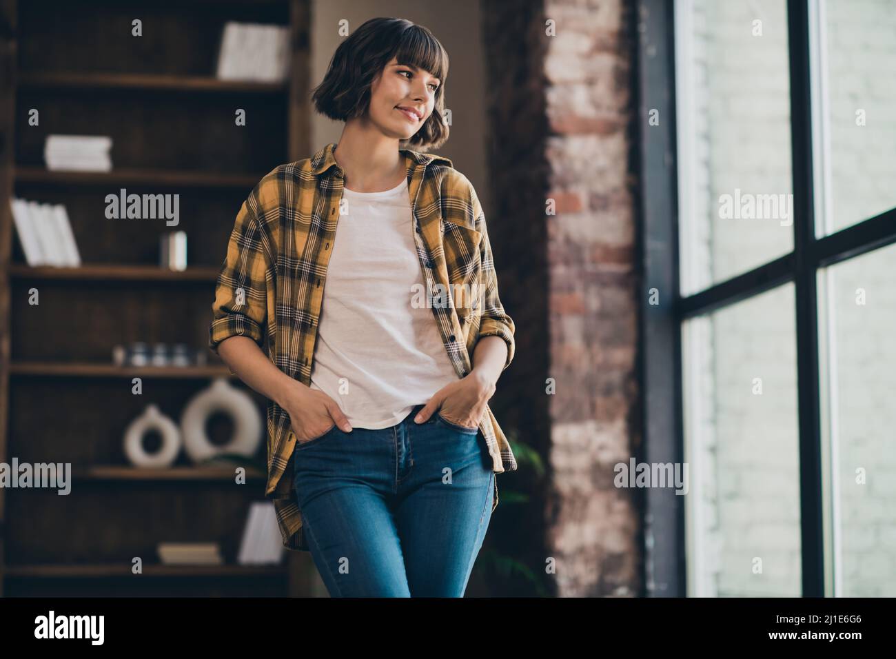 Photo of cute young bob hairdo lady look wear yellow shirt jeans at loft  home in flat alone Stock Photo - Alamy
