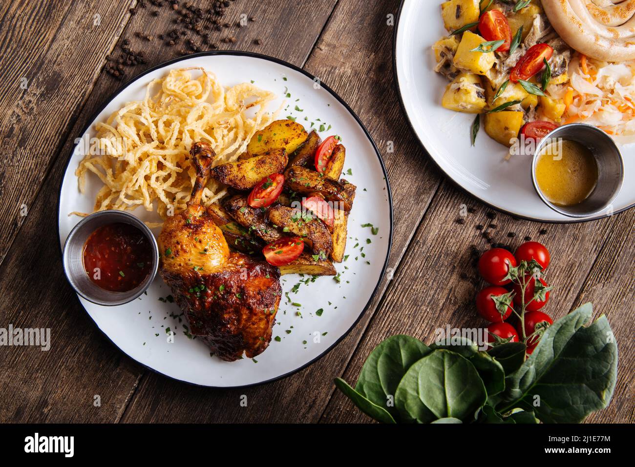 Baked chicken leg confit and german sausages Stock Photo Alamy