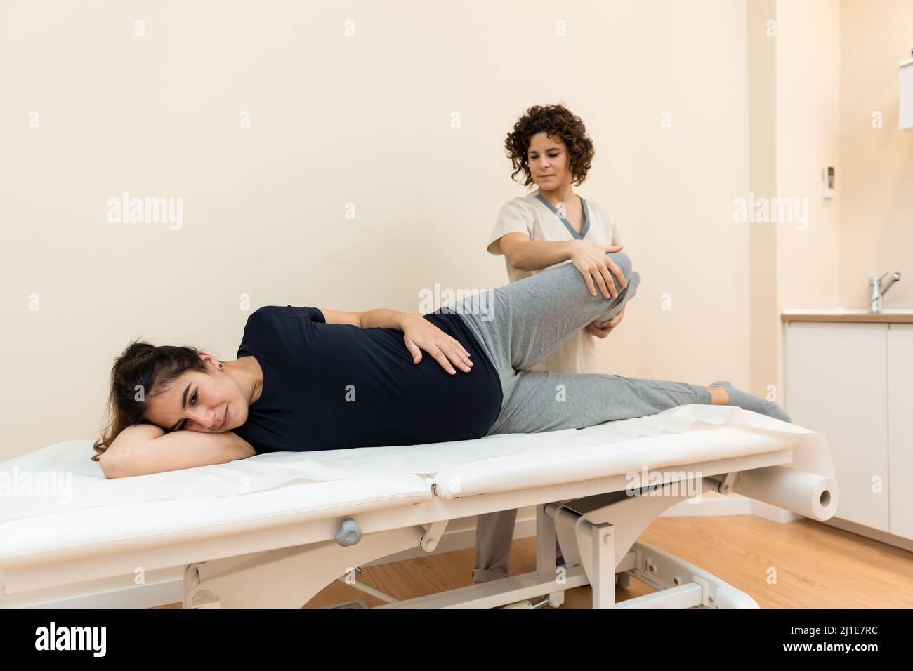 A pregnant woman lying on her side on a stretcher while a