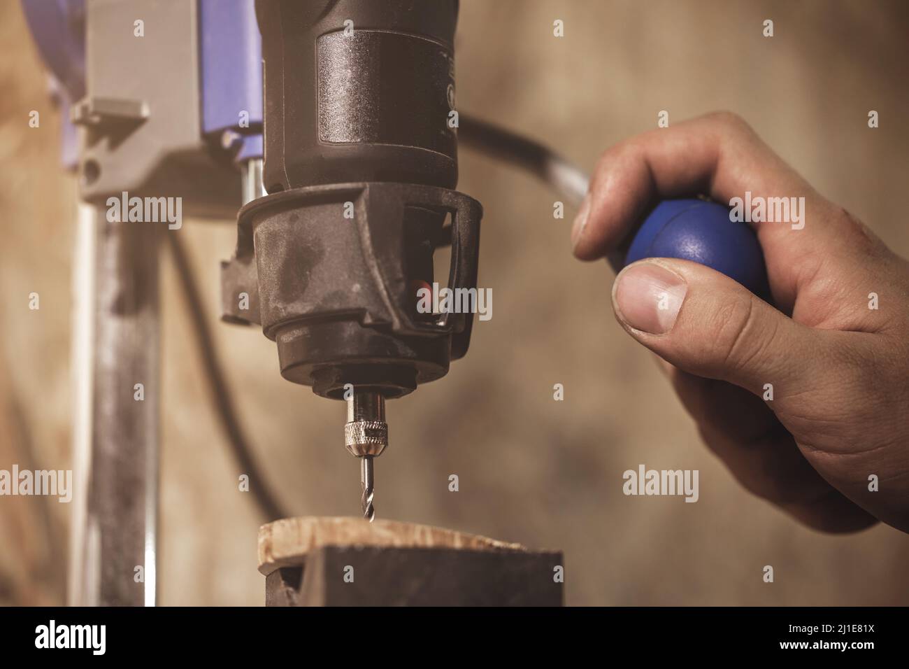 Carpenter is working on the drill machine Stock Photo