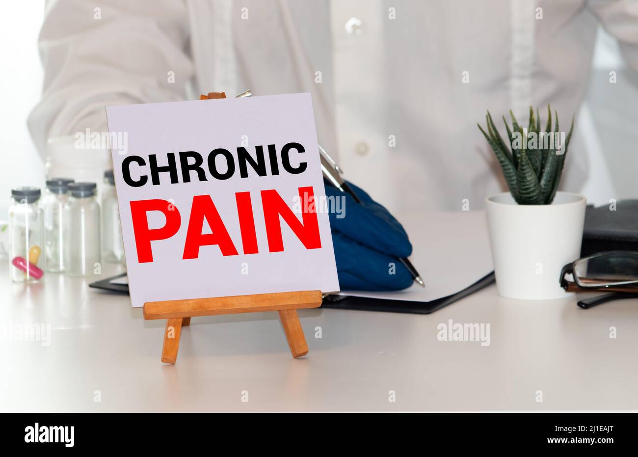 Doctor keeps a card with the name of the diagnosis chronic pain. Selective focus. Medical concept. Stock Photo