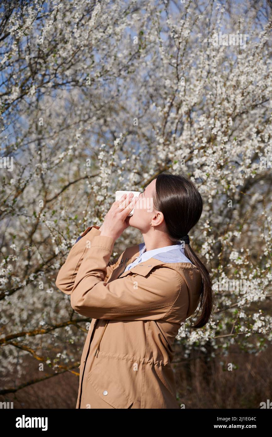 Woman allergic suffering from seasonal allergy at spring, posing in ...