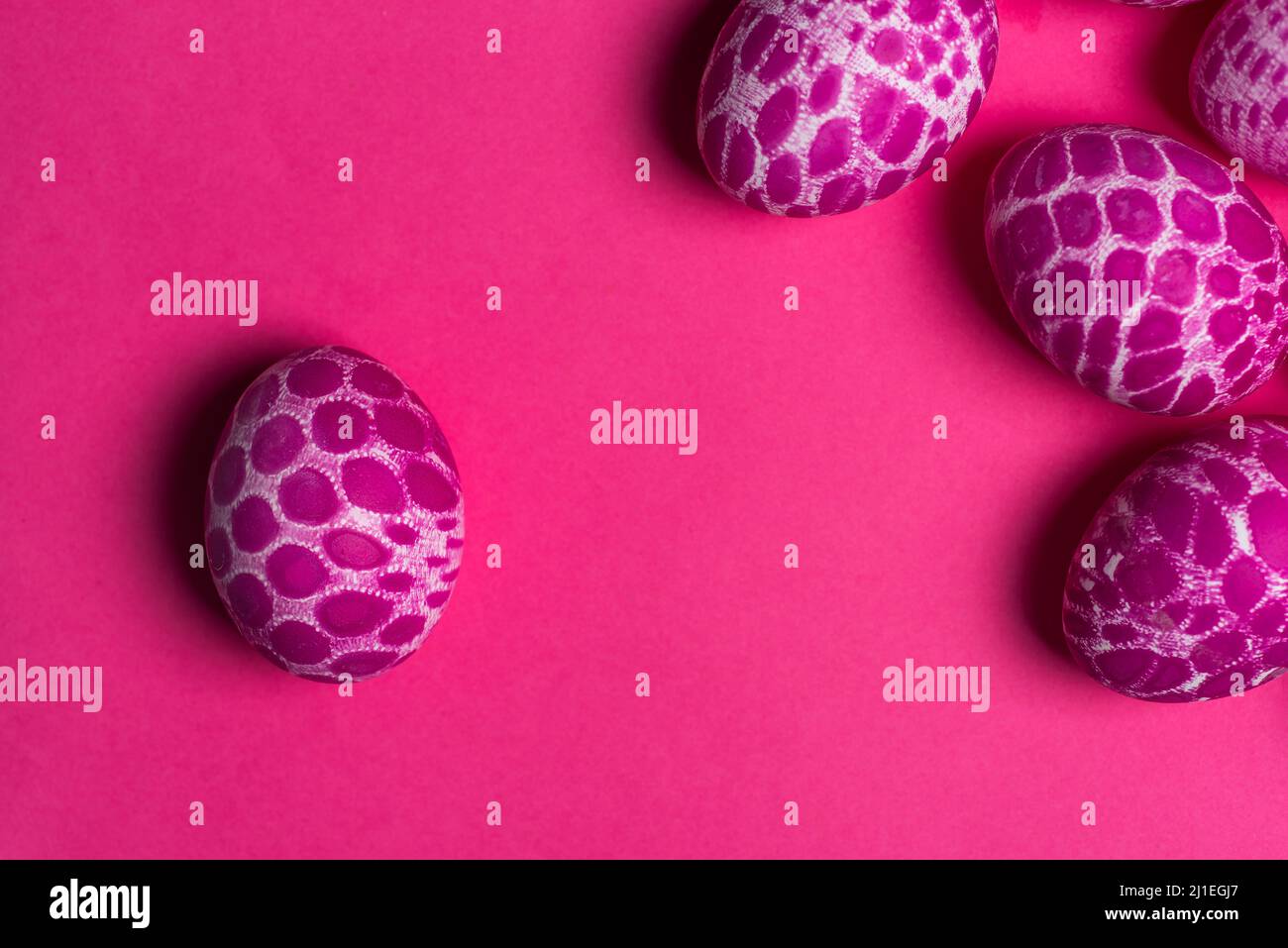 Lace pattern painted pink Easter eggs with copy space on pink background top view. Easter holiday abstract background Stock Photo
