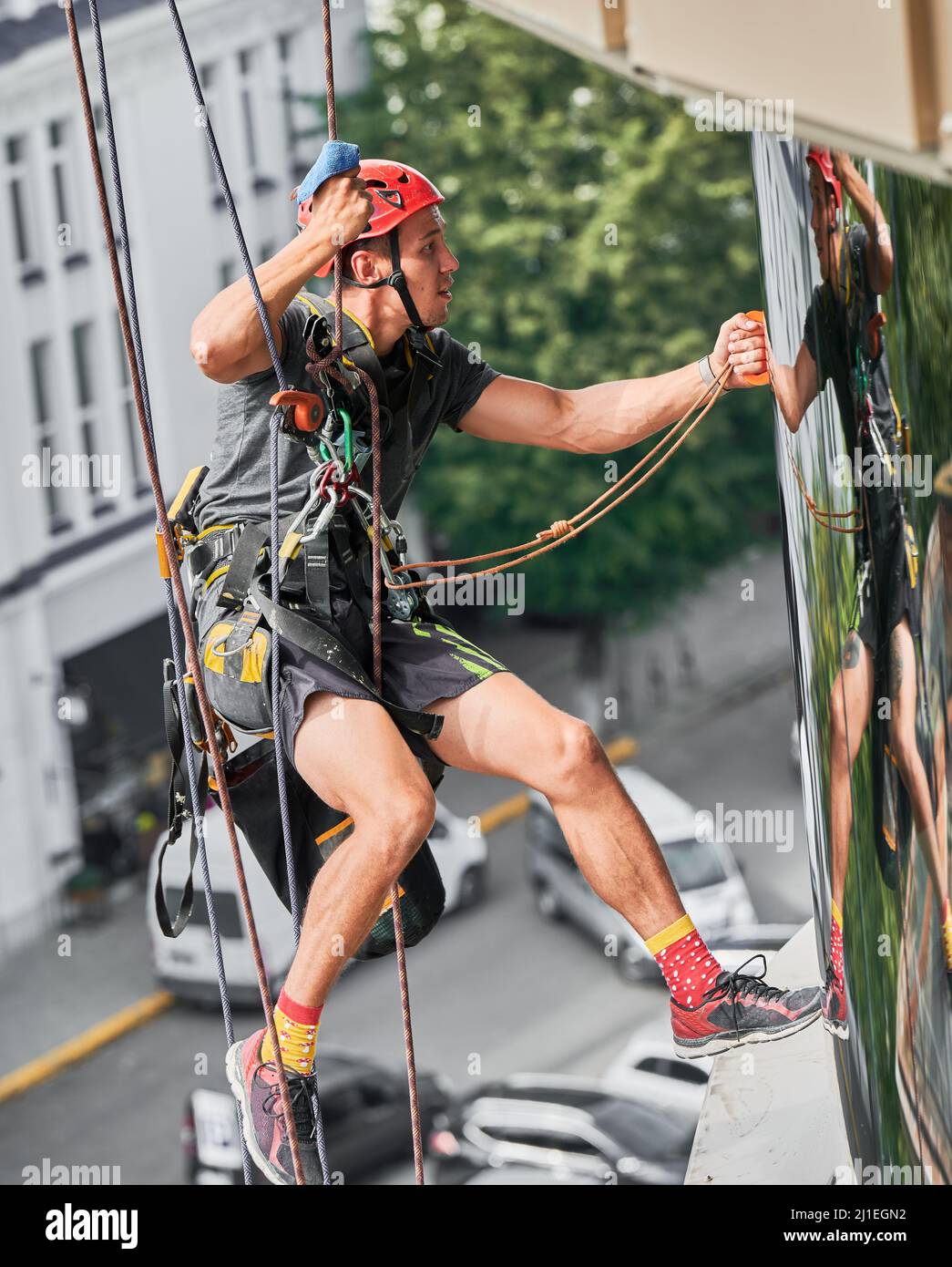 Industrial mountaineering professional cleaner hanging on safety