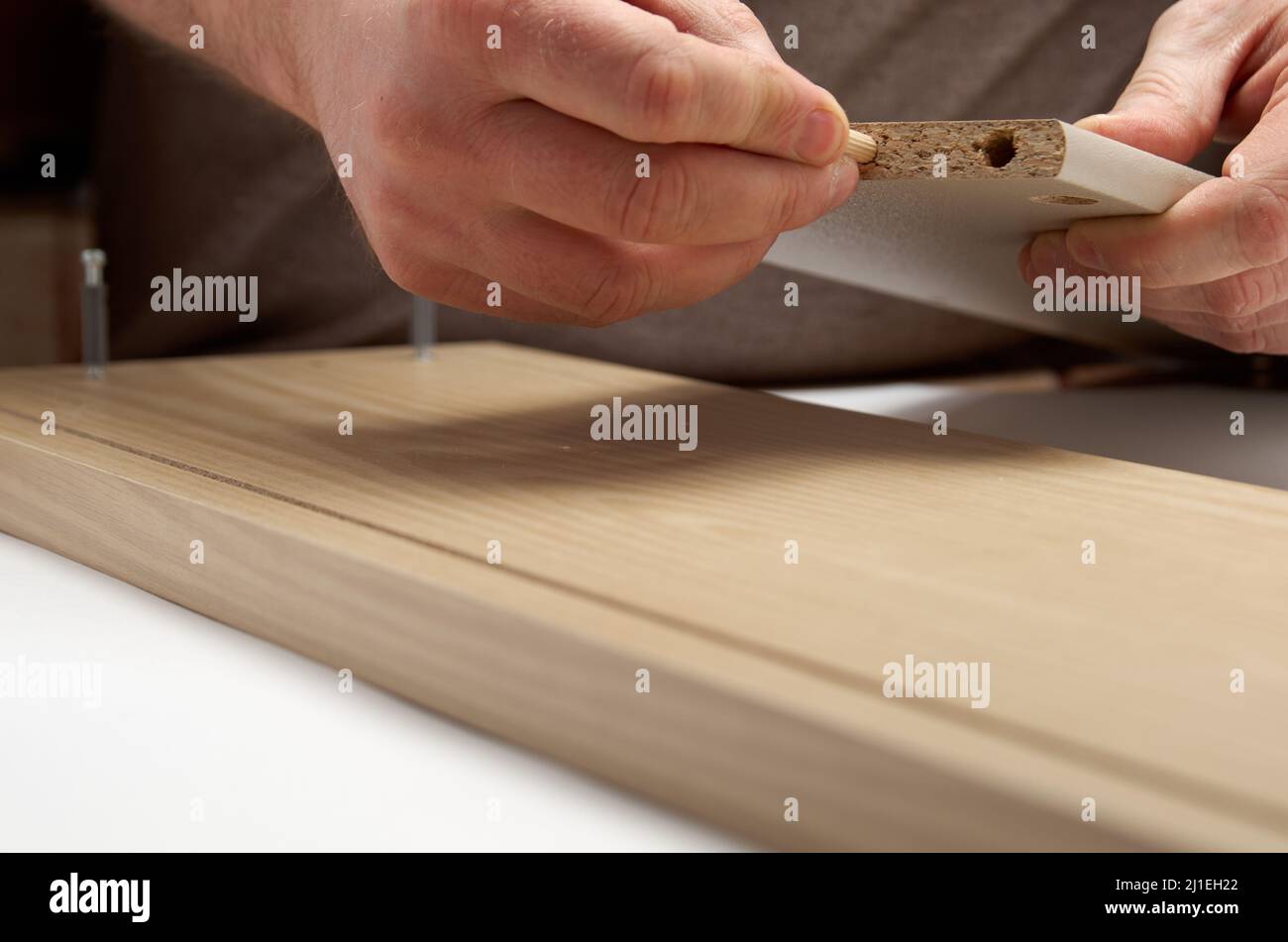 Furniture assembling install dowel to hole Stock Photo Alamy