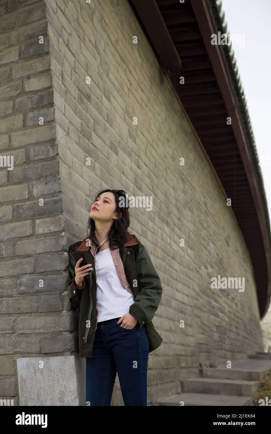 Female tourist texting against classical walls - stock photo Stock Photo