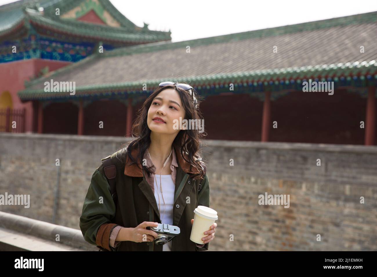 Young woman photographer walking on ancient city wall - stock photo Stock Photo
