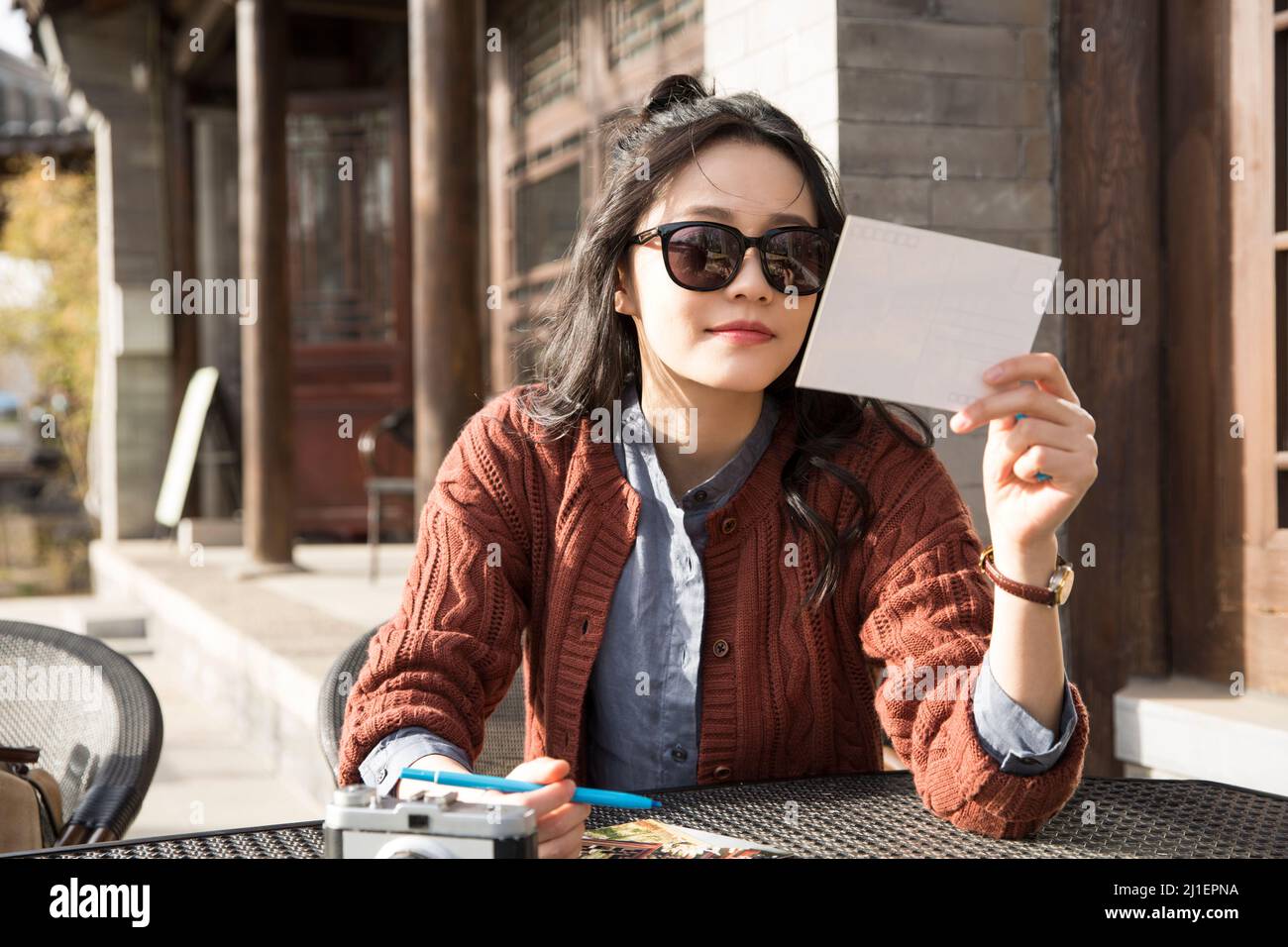 Female tourist writing postcard at an outdoor cafe - stock photo Stock Photo