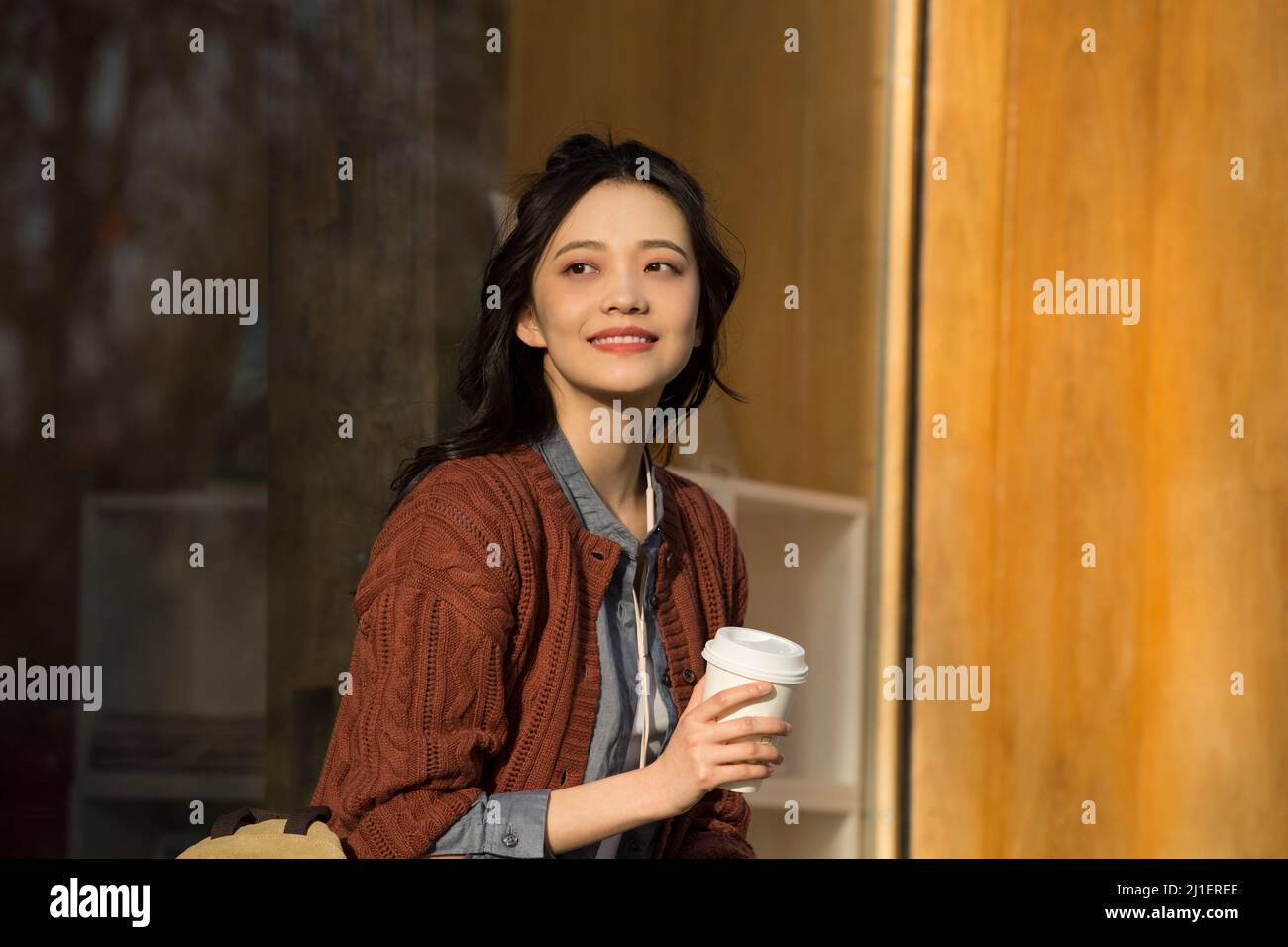 Chinese college student enjoying afternoon tea in sidewalk cafe - stock photo Stock Photo