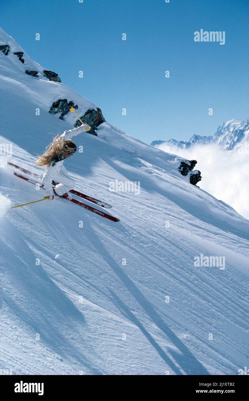 New Zealand. Young woman downhill skiing on alpine slopes. Stock Photo