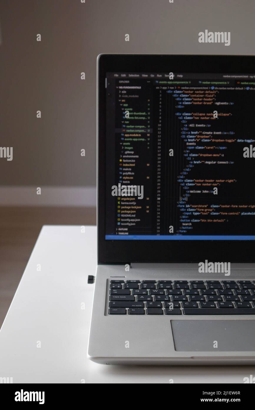 Opened laptop with code on the screen on the table Stock Photo