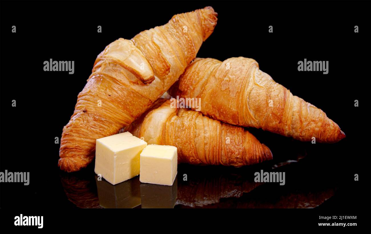 Fresh baked crusty croissants with butter. French buttery croissants on