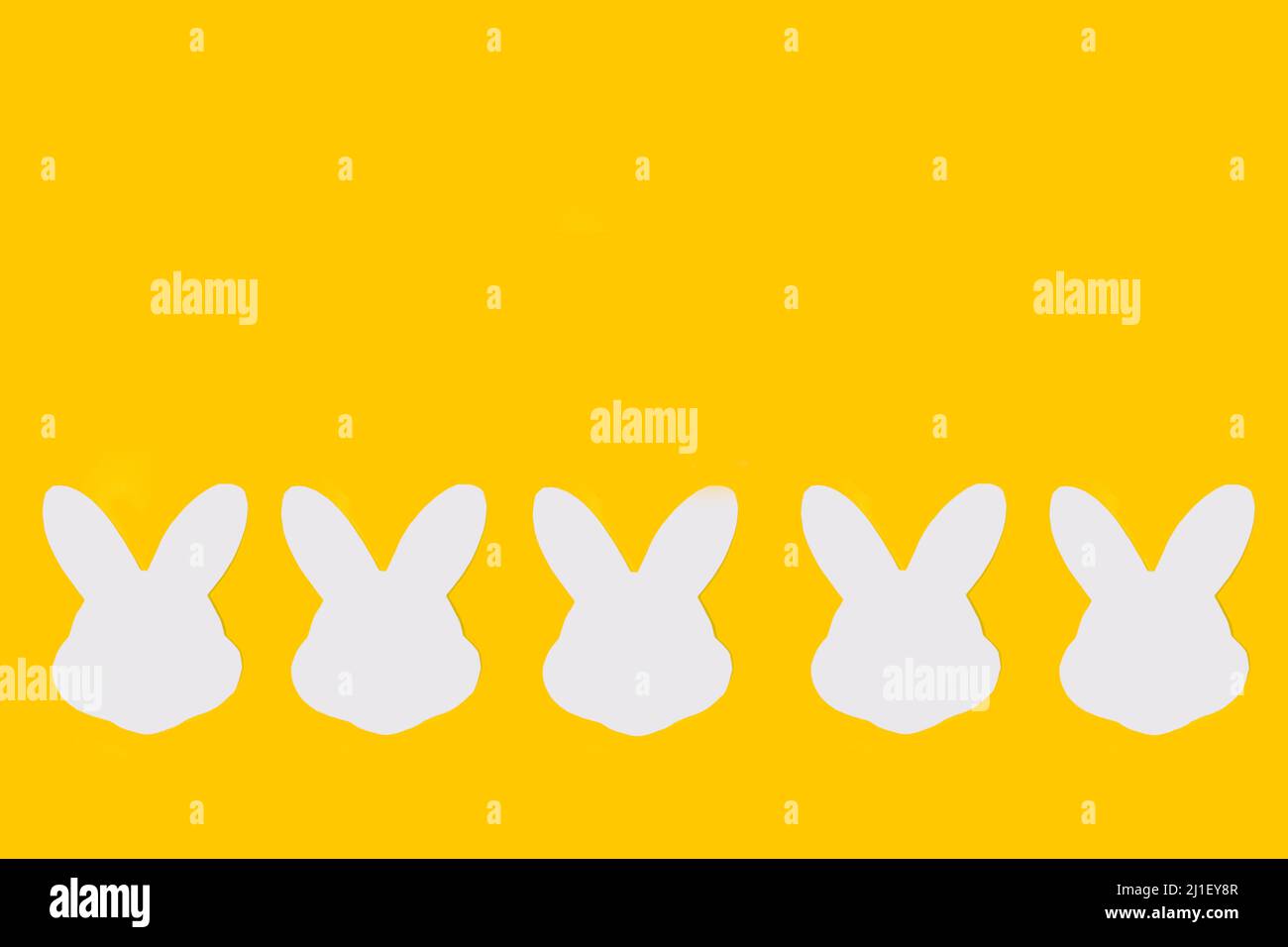 White paper rabbit heads on a yellow background with copy space Stock ...
