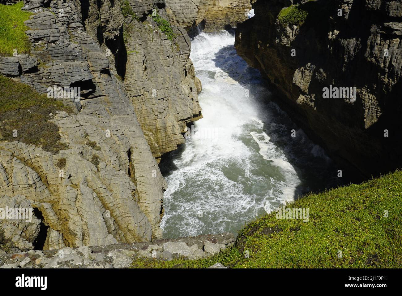 A high angle shot of a river flowing through its rocky banks covered ...