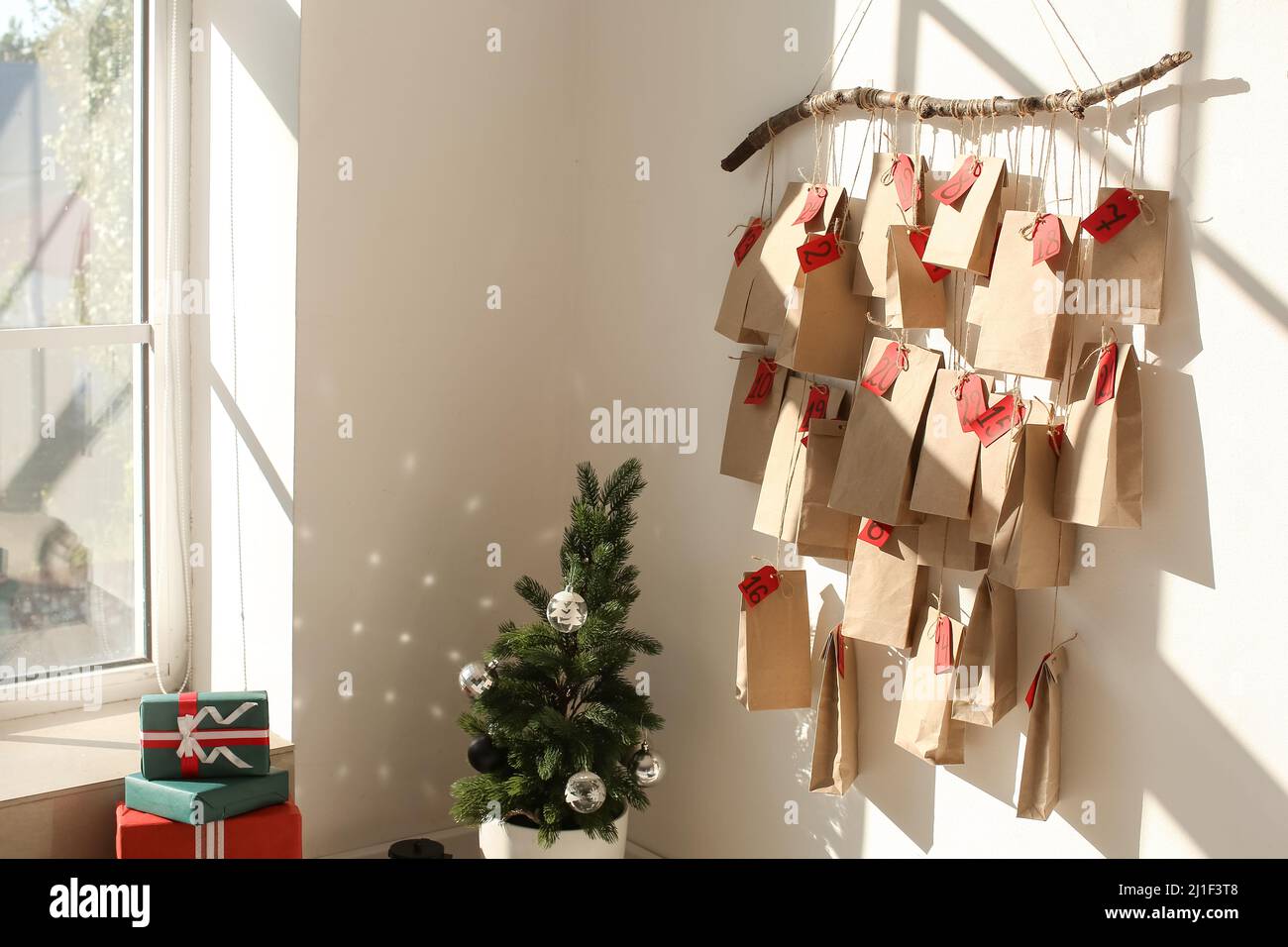 Christmas tree and advent calendar hanging on white wall in room Stock