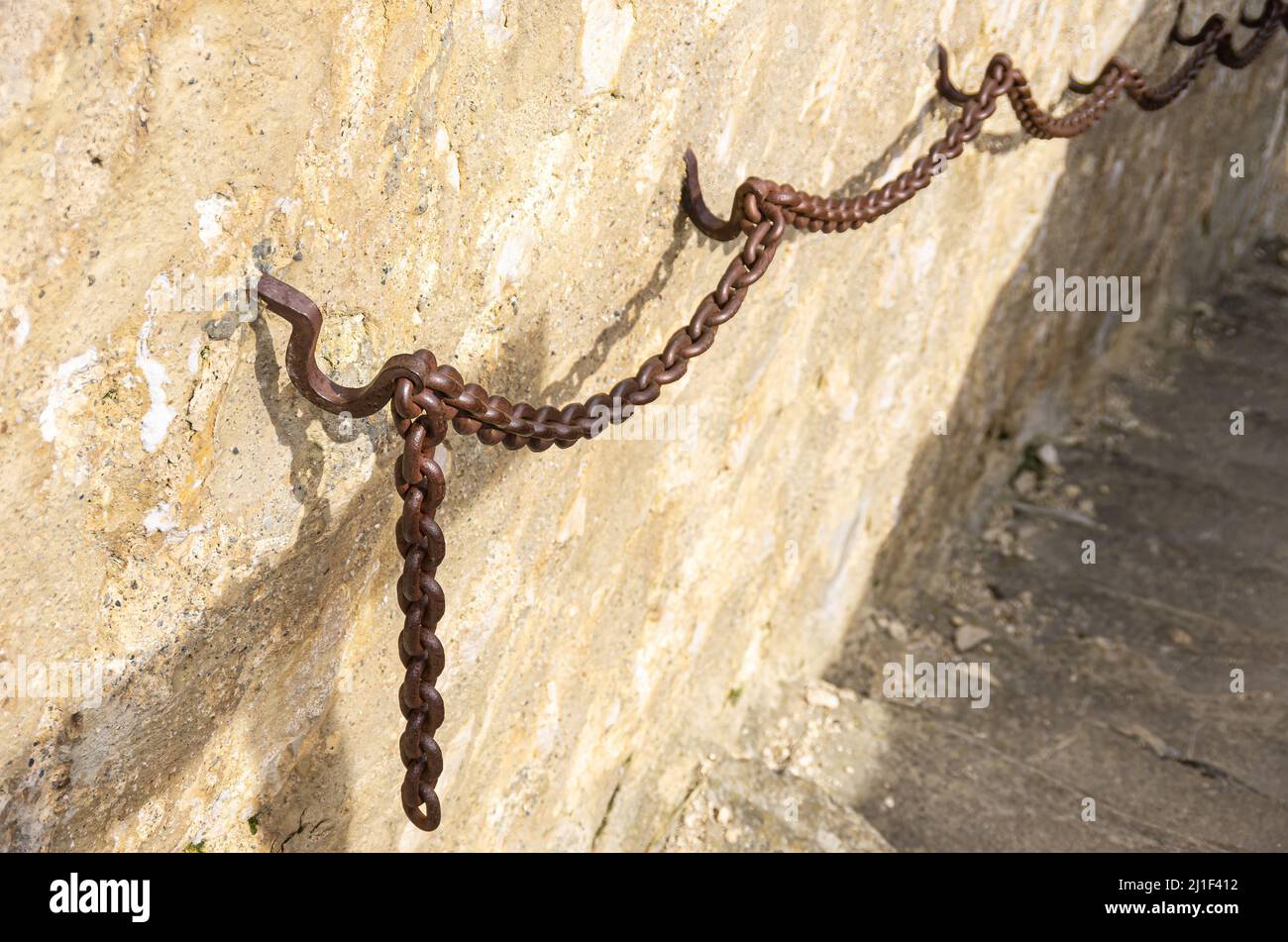 Heavy iron chain used as a banister or handrail on a medieval castle wall. Stock Photo