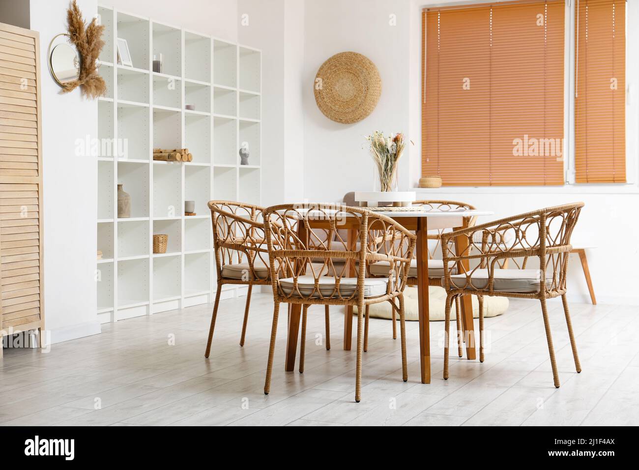 Interior of light dining room with table and shelving unit Stock Photo ...