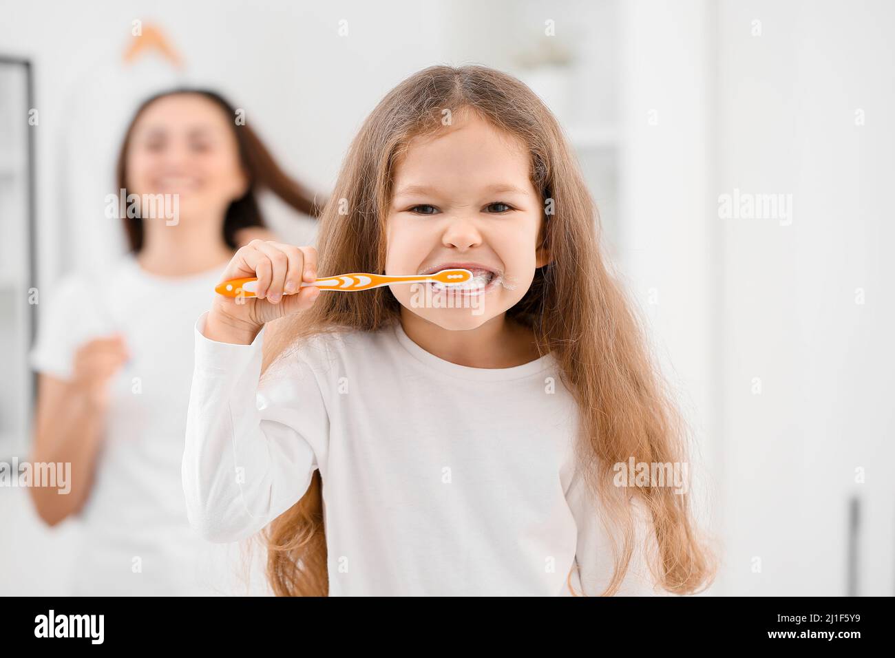 Funny little girl brushing teeth in bathroom, closeup Stock Photo Alamy