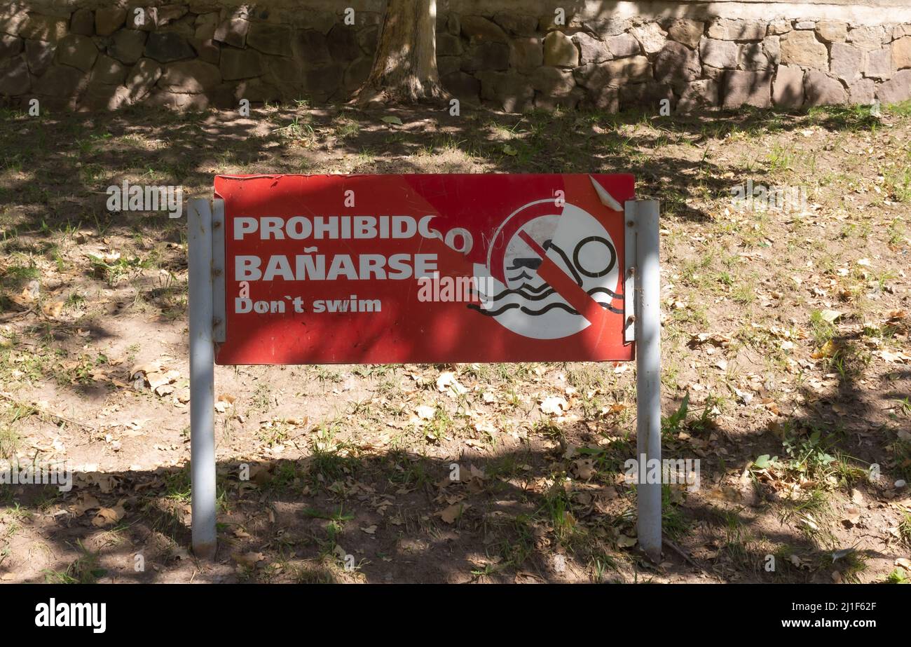 Sign indicating in english and  spanish: do not swim.. Stock Photo