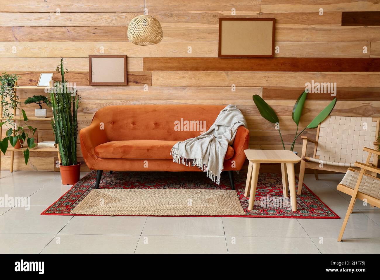Interior of stylish living room with red sofa, table and carpets Stock