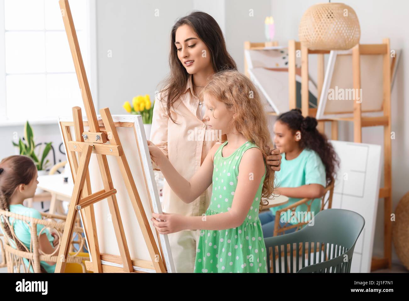 Cute girl and teacher during master-class in art Stock Photo