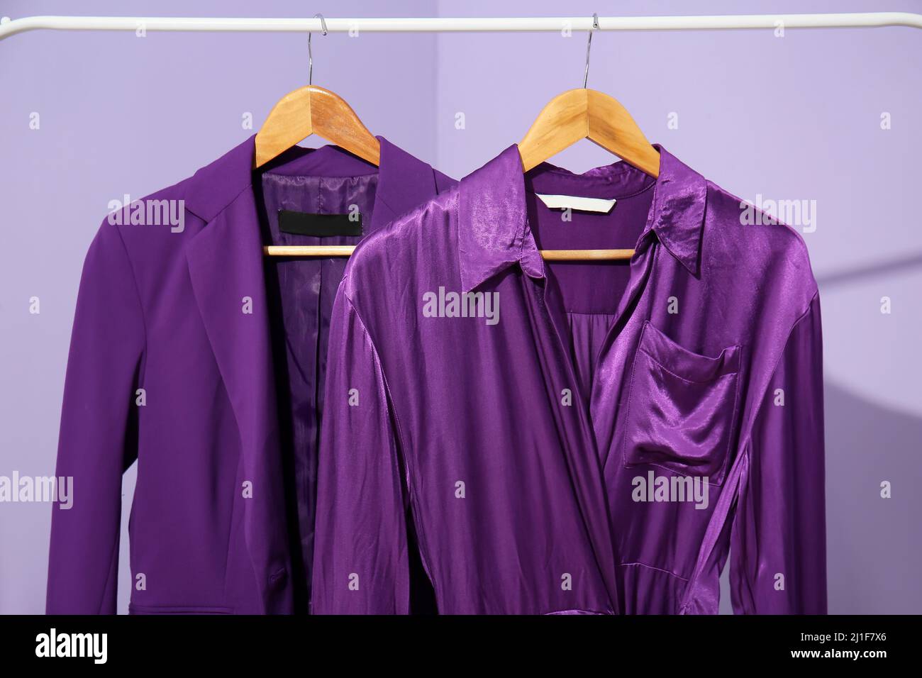 Purple Coat Rack Rack with purple clothes on lilac background Stock Photo - Alamy
