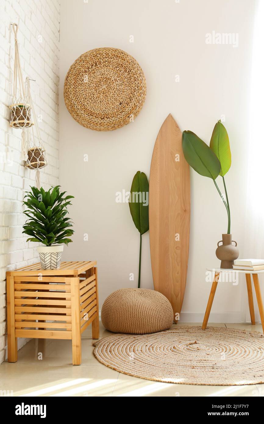 Interior of light room with wooden surfboard and houseplants Stock ...