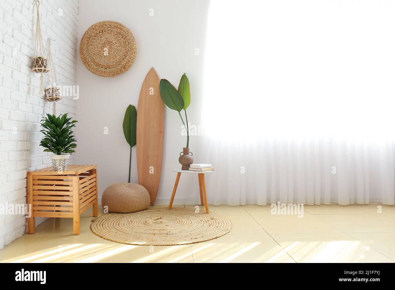 Interior of light room with wooden surfboard and houseplants Stock ...