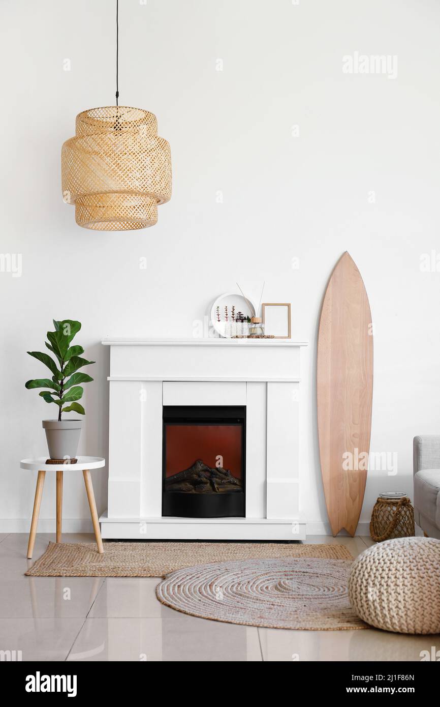 Interior of light living room with wooden surfboard and fireplace Stock ...