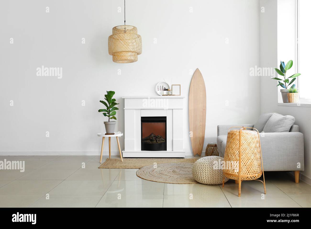 Interior of light living room with wooden surfboard and fireplace Stock ...