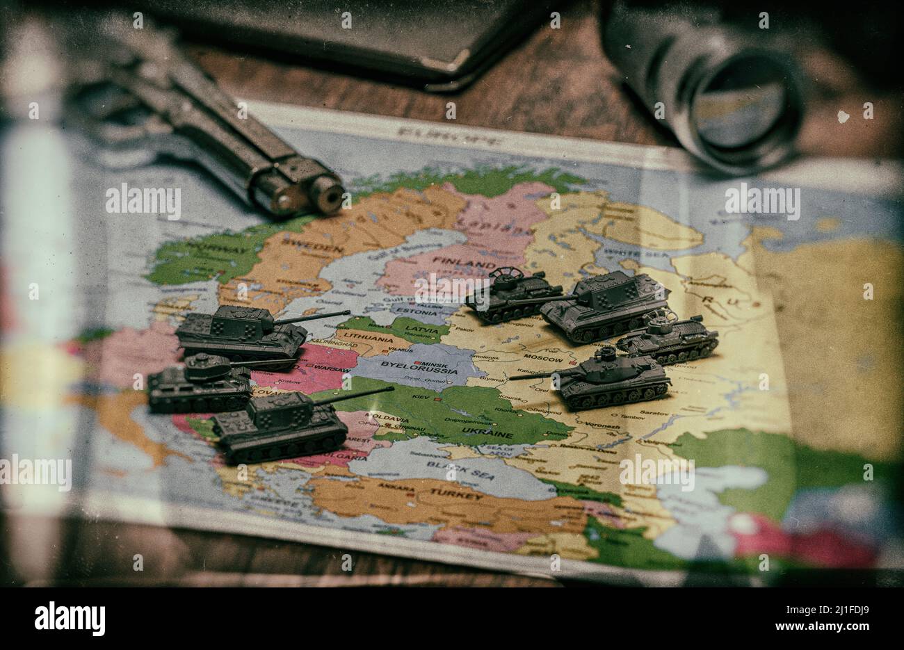 Toy tanks on the map. Concept of confrontation between NATO and Russia. Stock Photo