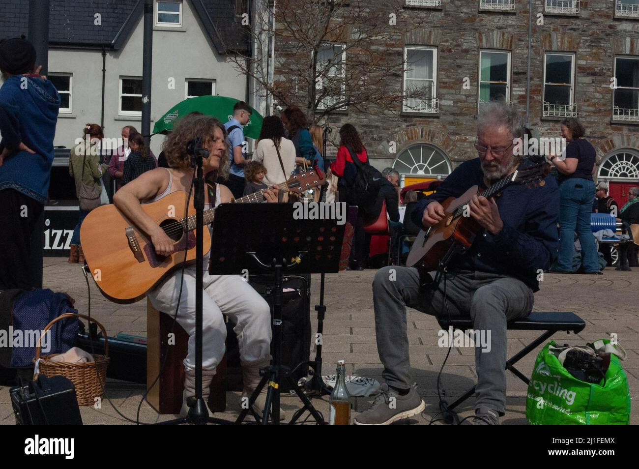 Bantry, West Cork, Ireland, Friday 25 Mar 2022; The sun shone on Bantry Market today drawing people out. Many people where out in t-shirts with tempratures hitting 22 degrees. Musicans serenade the people shopping at Bantry's friday market. Credit ED/Alamy Live News Stock Photo