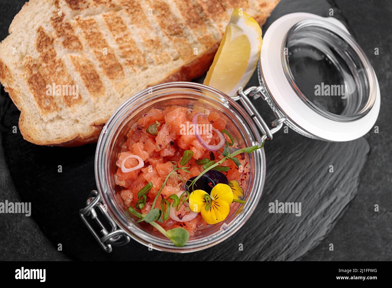 Salmon tartar with toast, in a glass jar Stock Photo