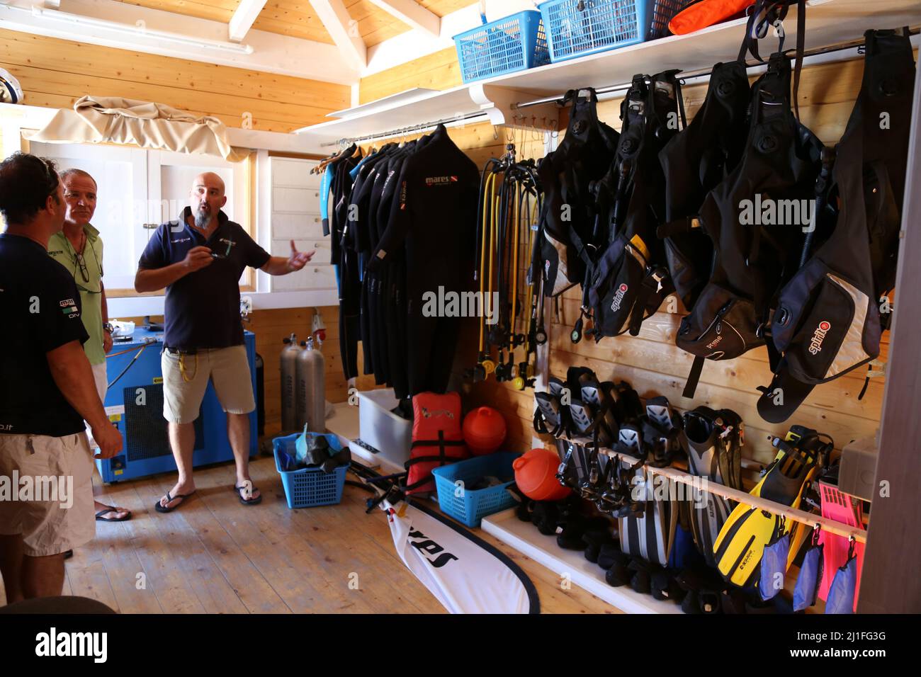Diving instructors inside of a diving retail centre talking in front of the scuba equipment