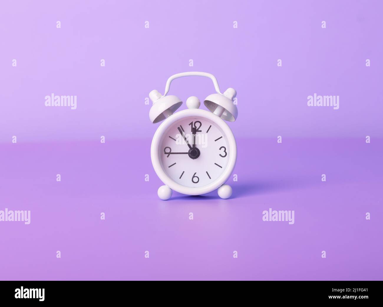 Retro alarm clock on purple, violet, very peri background. Time concept