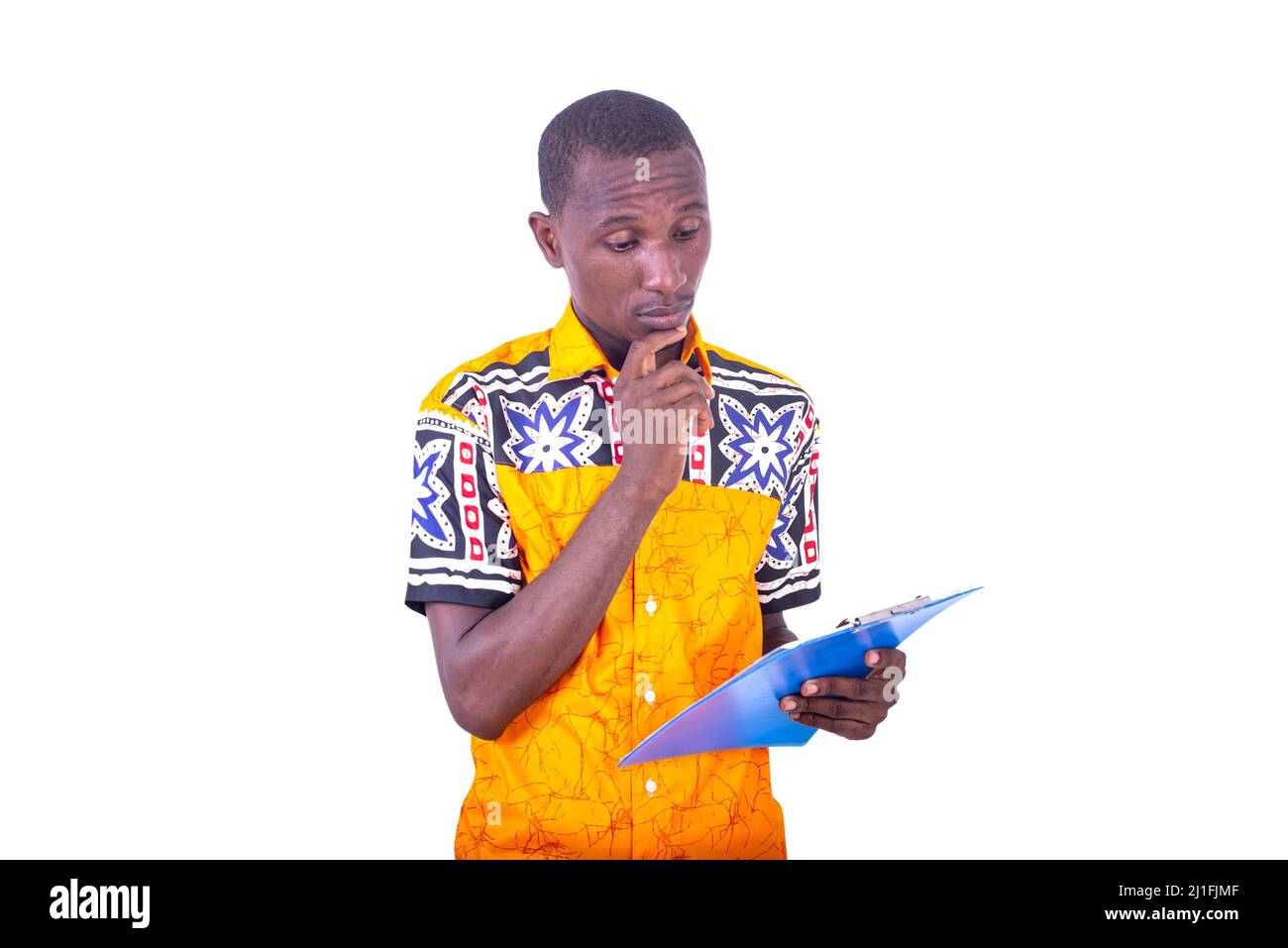 serious young man standing and reading clipboard in hand Stock Photo ...