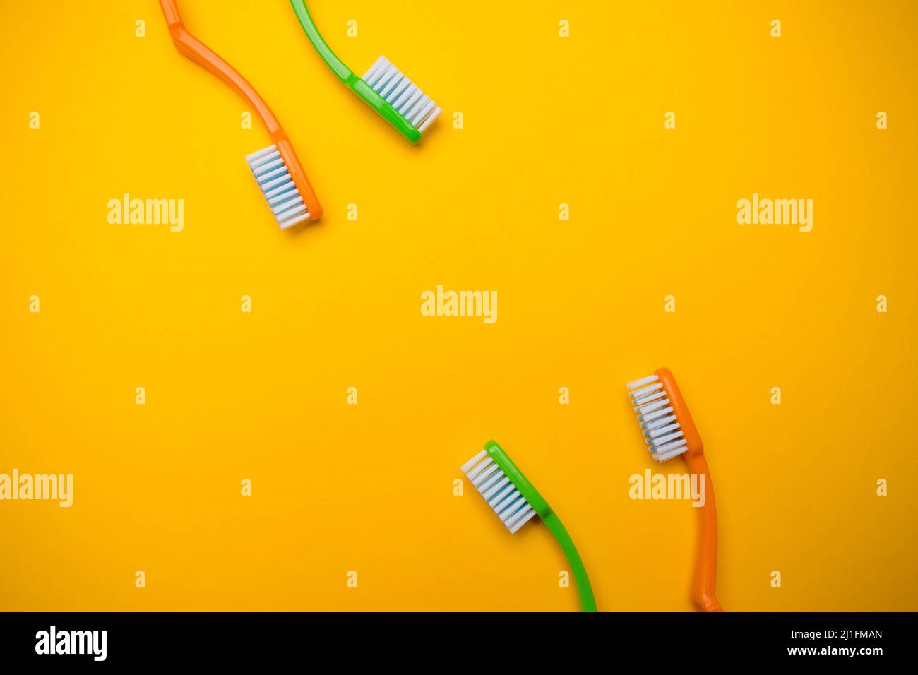 Oral and dental health concept showing two toothbrushes on a yellow ...