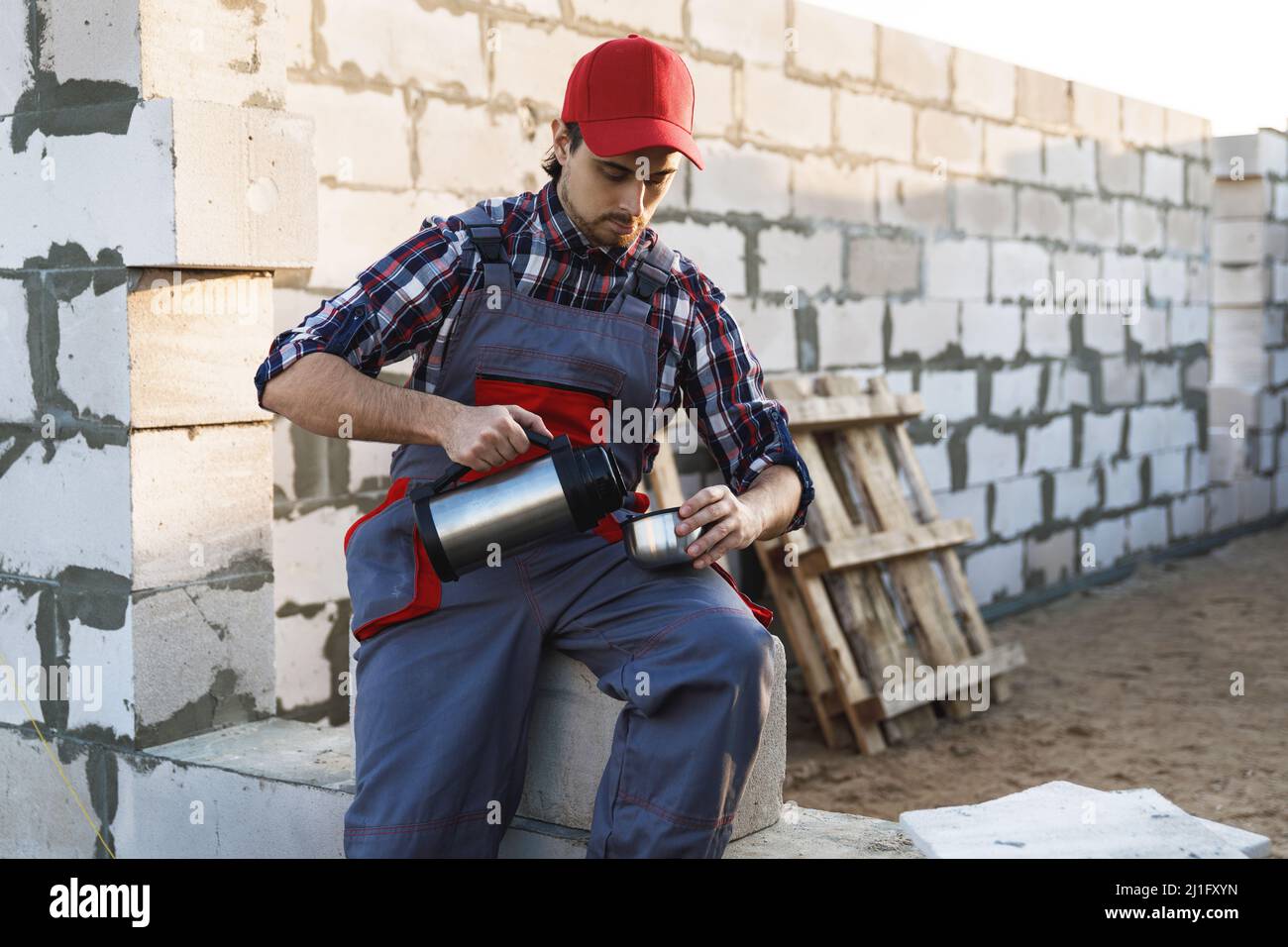 Bricklayer during the coffee break at the work Stock Photo