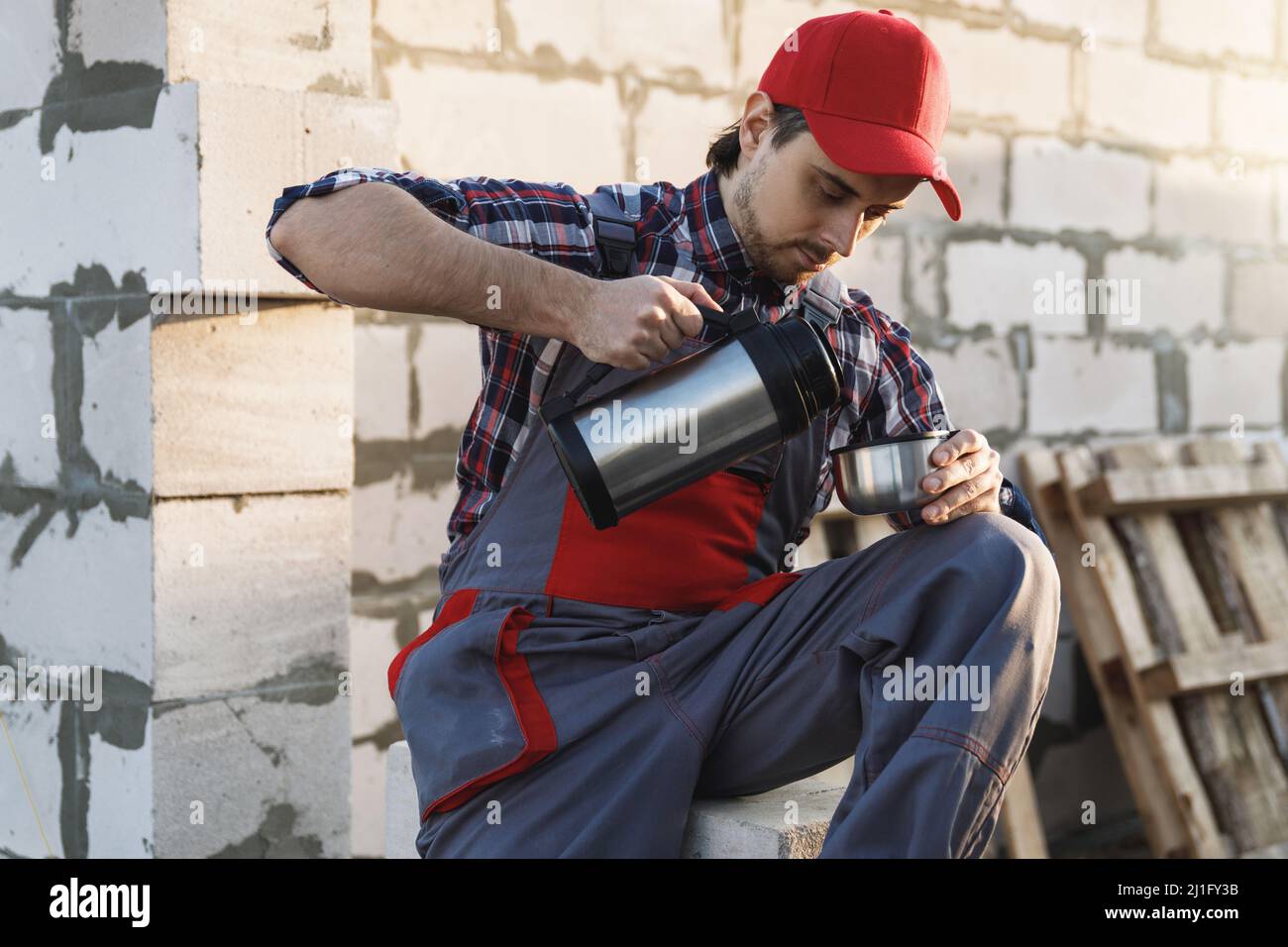 Bricklayer during the coffee break at the work Stock Photo