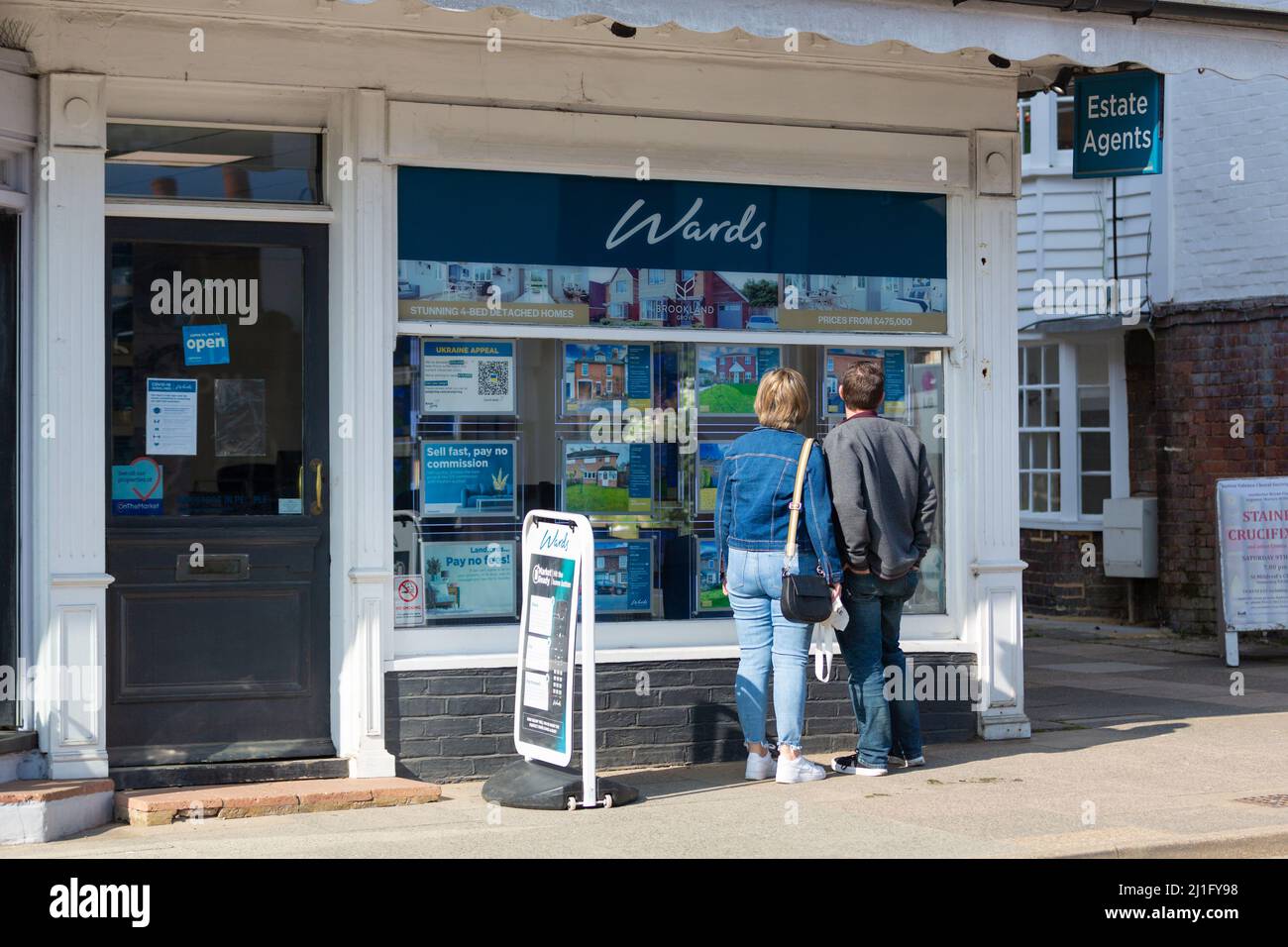A couple looking at wards estate agents window, tenterden, kent, uk