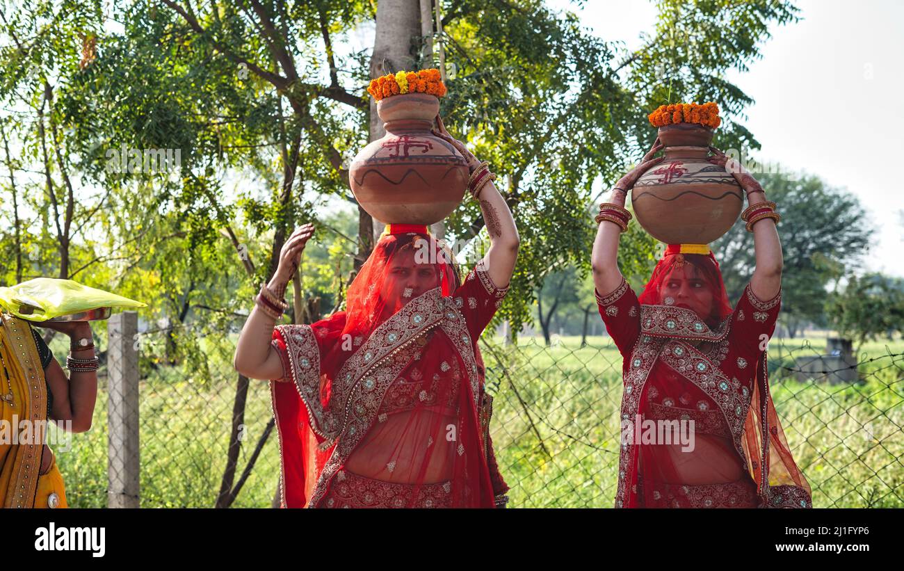 23 March 2022 Reengus, Rajasthan, India. Traditional Indian women holding Clay Kalash on head on a Hindu festival. Hindu religion concept. Stock Photo