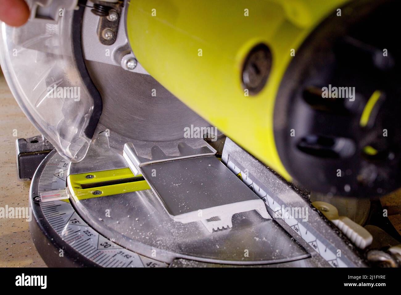 Worker cutting baseboard on the circular saw before installing Stock