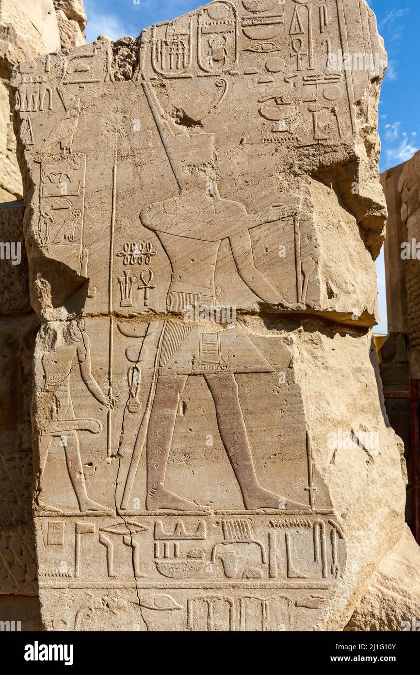 Bas-relief of pharaoh wearing the deshret, or red crown, making an offering to a deity, Temple of Karnak, Luxor Stock Photo