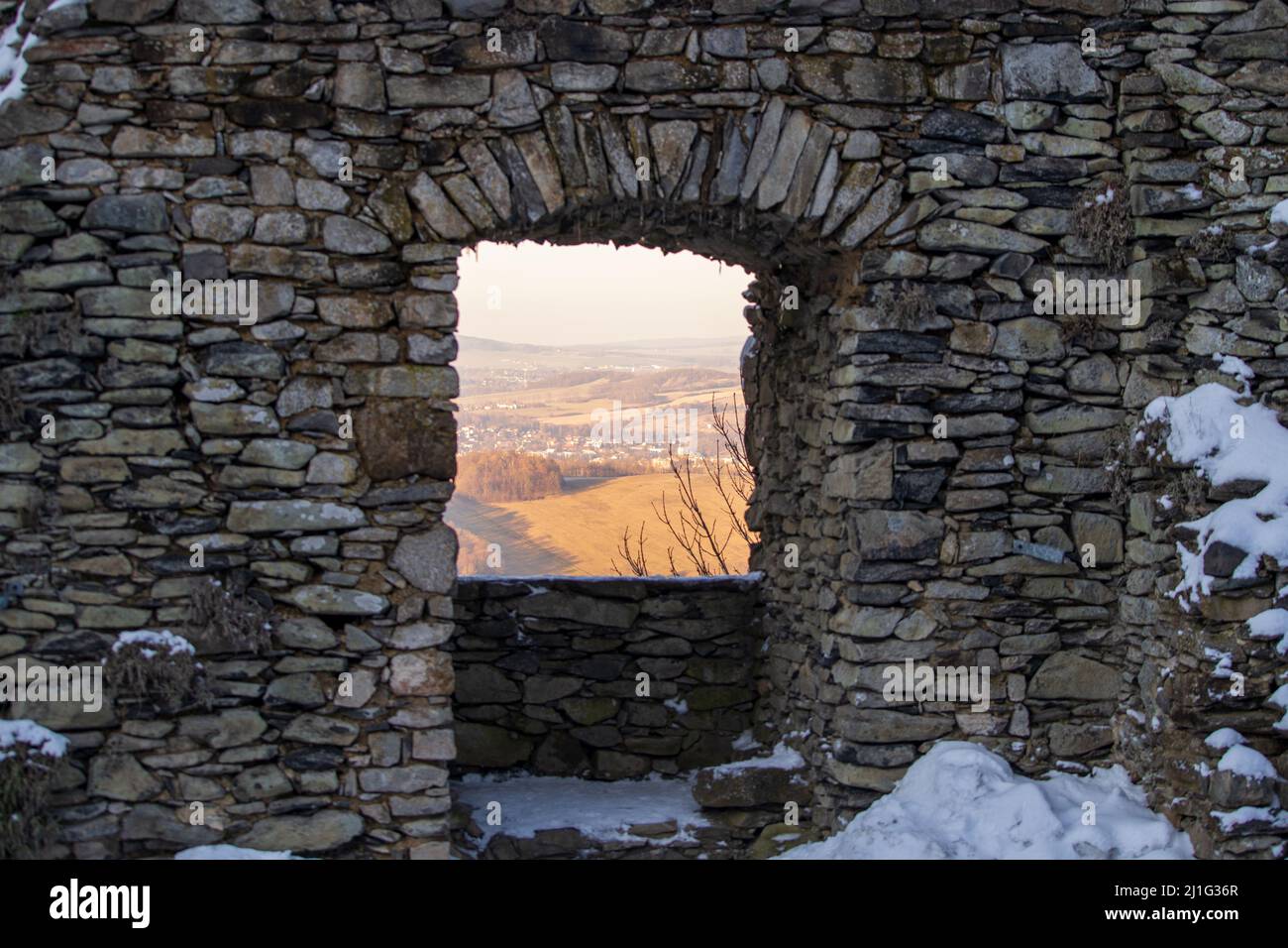 looking at a landscape through old stone window of a castle ruin Stock Photo