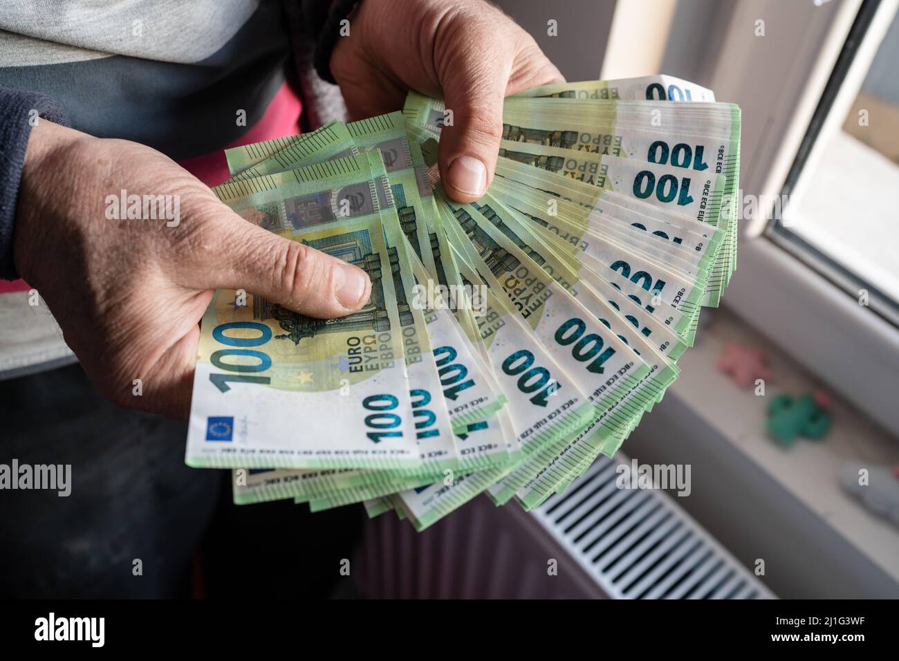 Close up on hands of unknown caucasian senior man holding and counting 100 euro banknotes money wealth insurance payment or lifetime savings copy spac Stock Photo