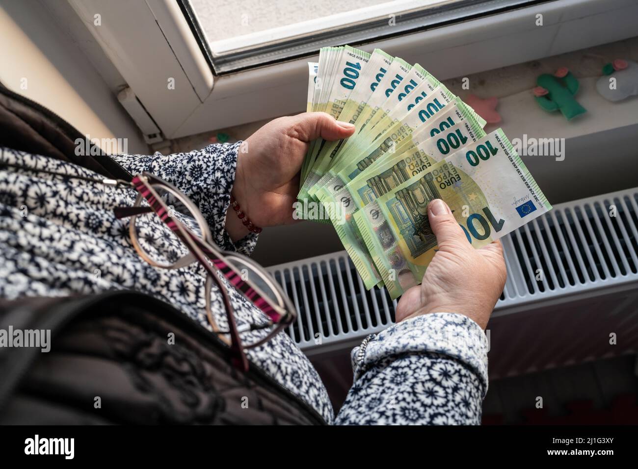 Close up on hands of unknown caucasian senior woman holding and counting 100 euro banknotes money wealth insurance payment or lifetime savings copy sp Stock Photo