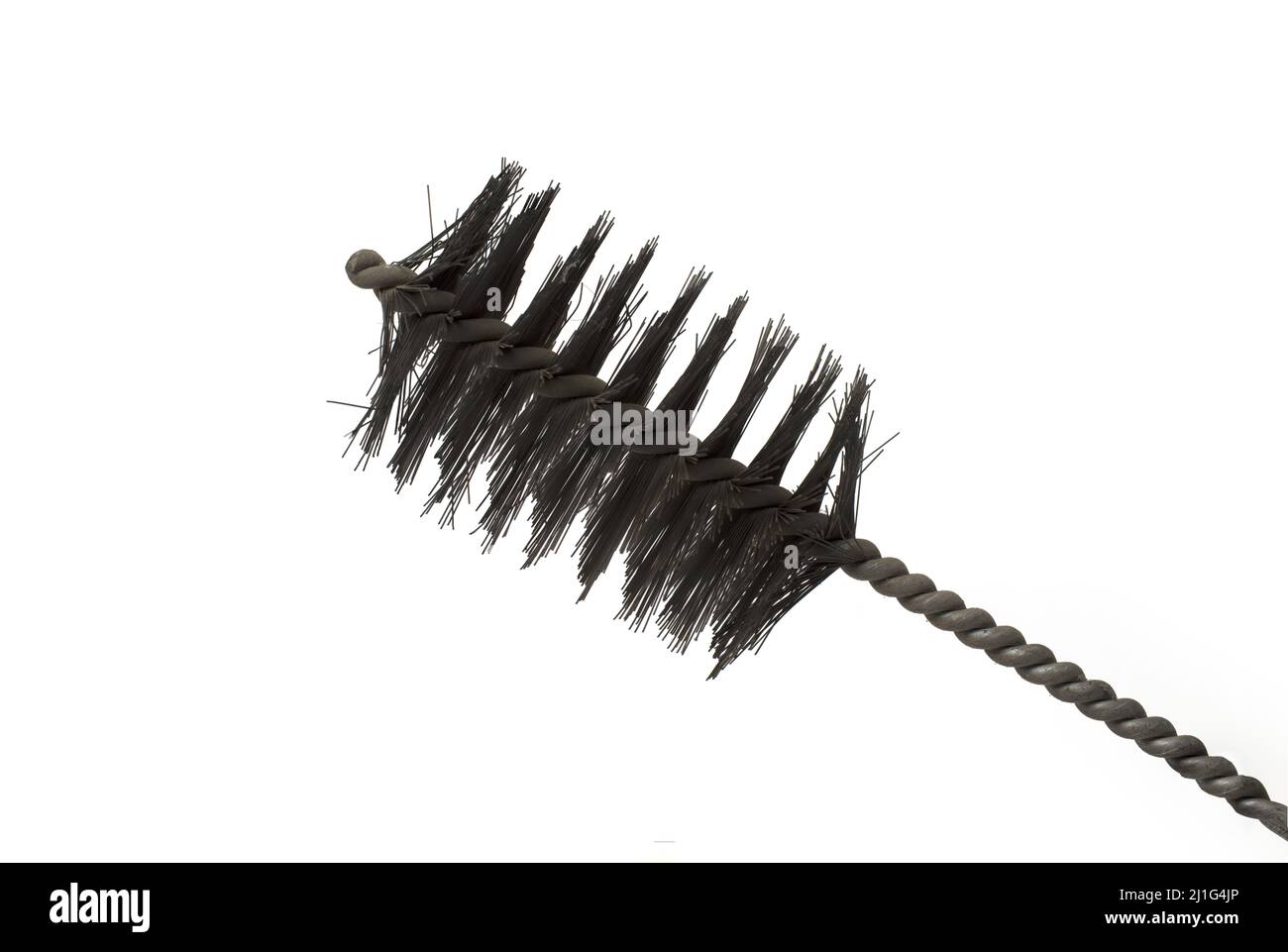 Close up of a sooty black metal steel wire brush for cleaning heaters