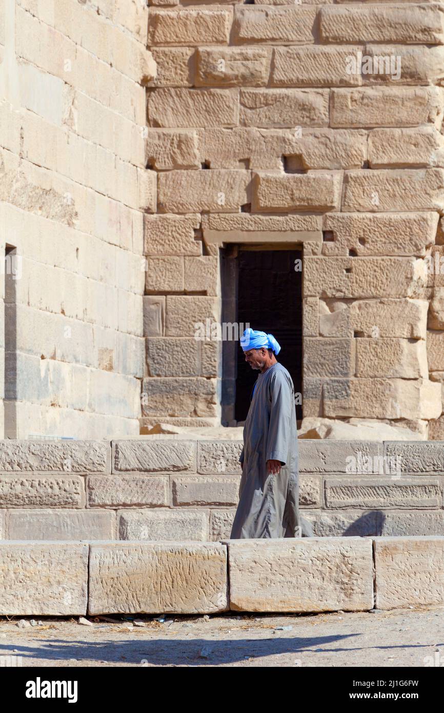Local Egyptian walking in front of the first pylon of the Temple of Isis at Philae Stock Photo