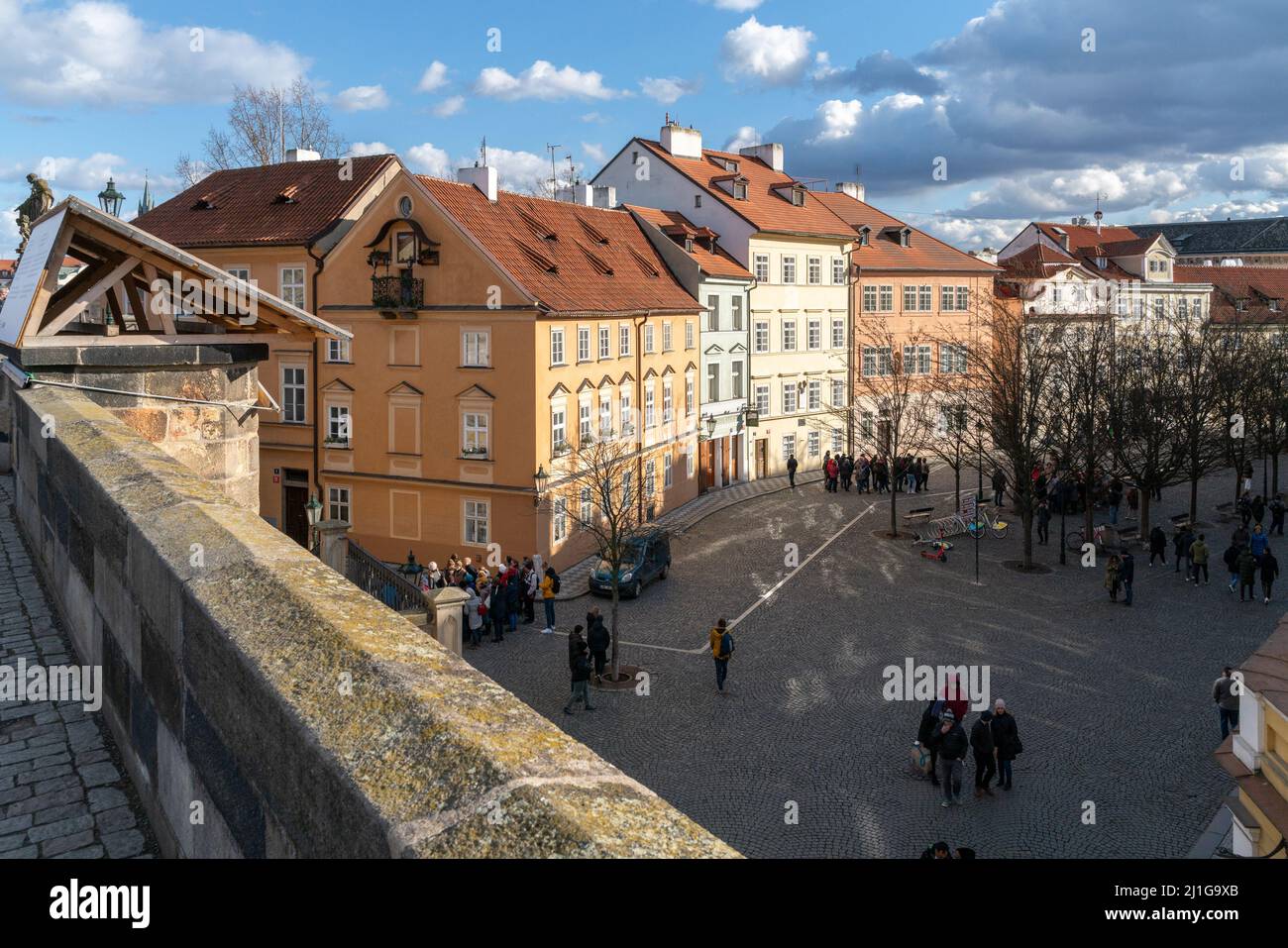 Prague, Czechia - 02.19.2022: Groups of people in Na Kampe street in the historical city center, viewed from Charles Bridge. Beautiful sunny day of Stock Photo